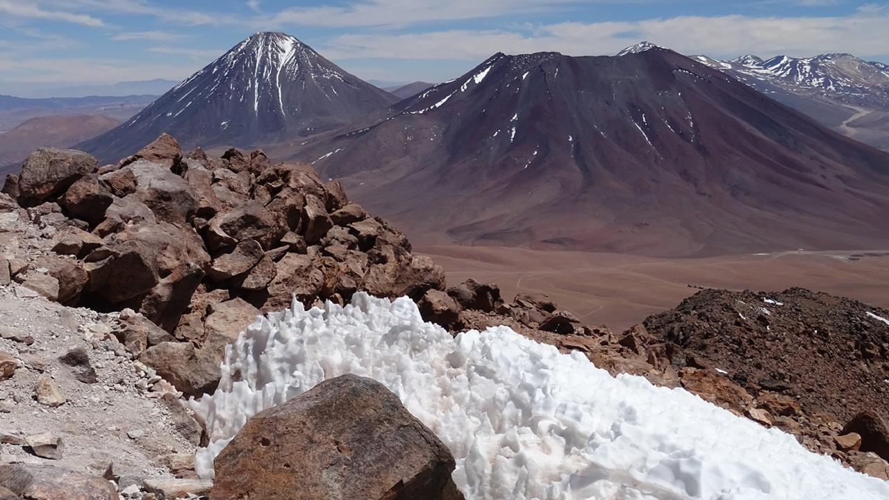 Uitzicht op 5600 meter hoogte over penitentes naar de vulkaan Licancabur, Chili.