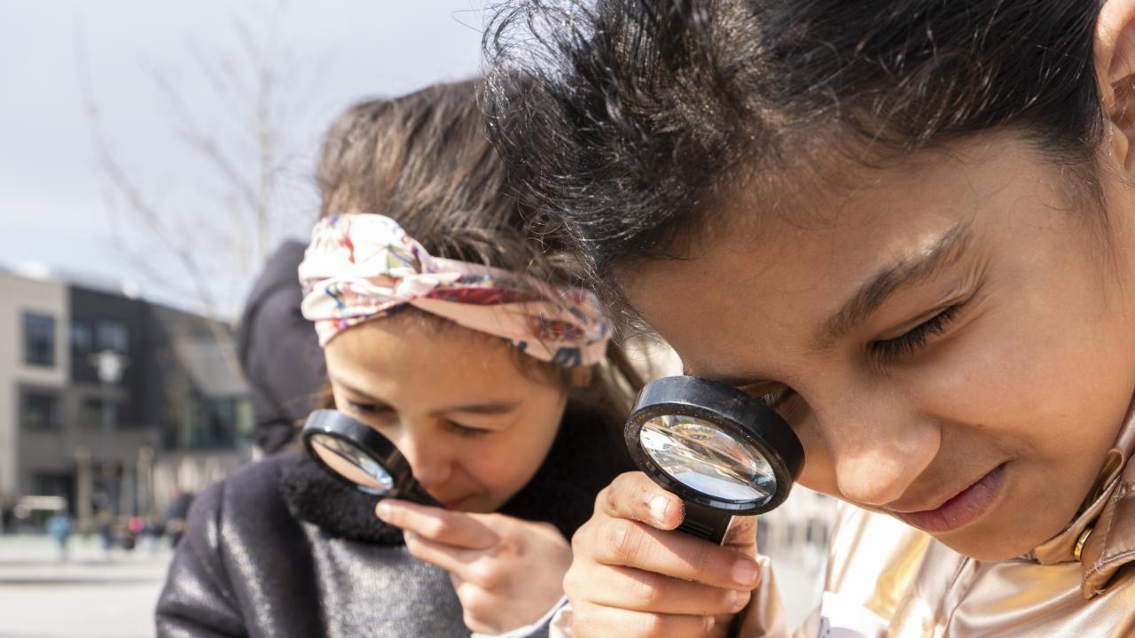 Kinderen kijken door een vergrootglas