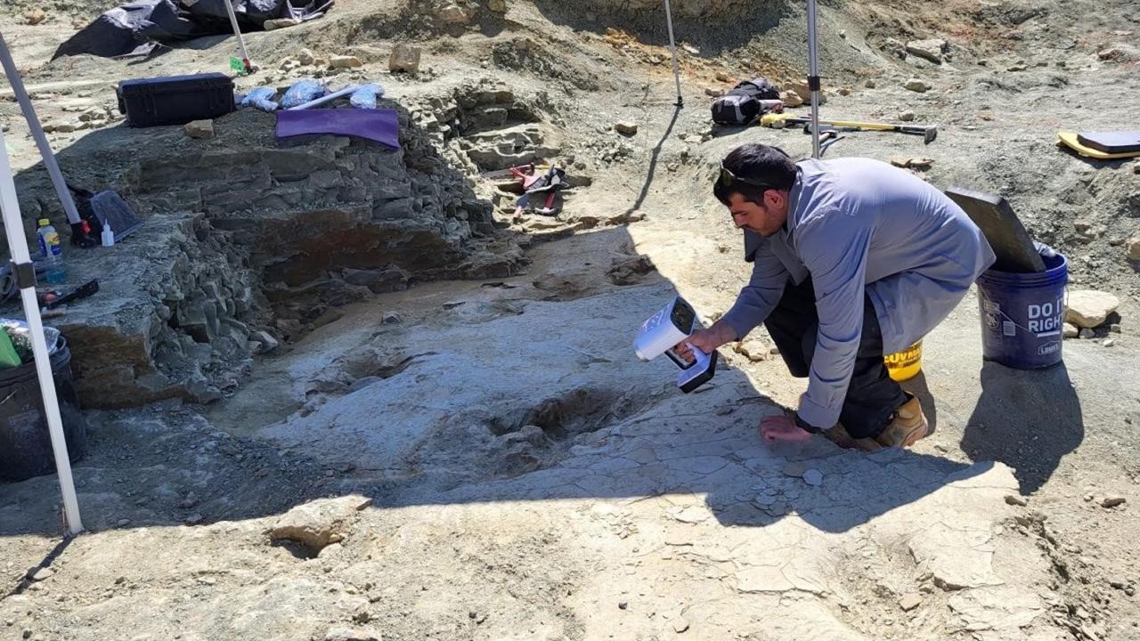 Panos Skandalos scant de voetafdrukken van een dinosaurs met een 3D-scanner