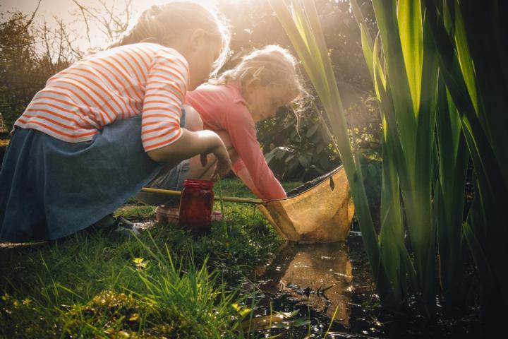2 kinderen zoeken naar dieren in een vijvertje