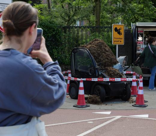 Voorbijganger maakt een foto van de stadauto met triceratopspoep